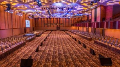 A conference hall arranged with rows of seats and tables